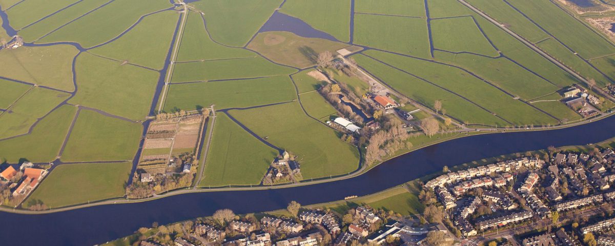 Aerial view of a village separated from green fields by a canal, The Netherlands